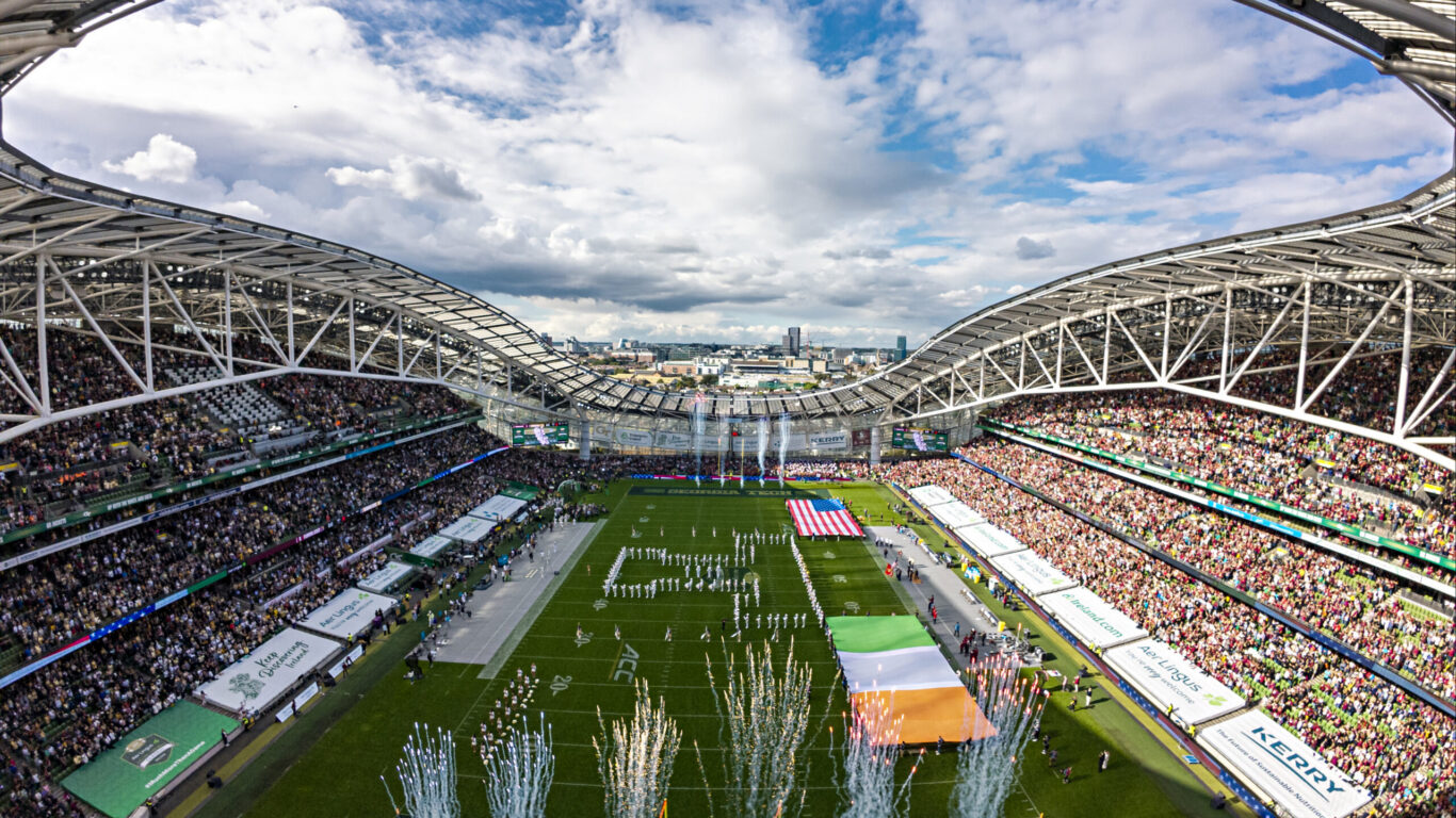 Expansive stadium view with cheering crowds, pyrotechnics, and vibrant field. Ideal for sports event accommodation.
