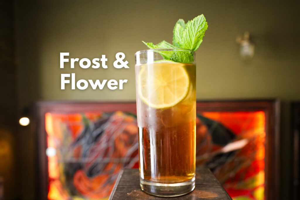 Elegant cocktail with lemon and mint at stylish hotel bar, Frost & Flower, offering a unique ambience.