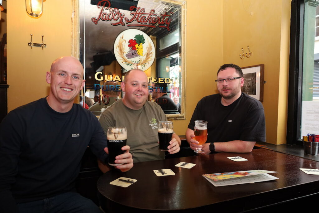 Cosy Pub Experience with Pints Guests enjoying pints in a cosy pub with a vintage mirror and warm lighting, perfect for socialising and relaxing.