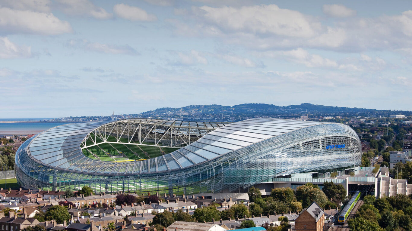 Aviva Stadium in Dublin with scenic hills and sea view, inviting guests to enjoy a vibrant stay near iconic landmarks.